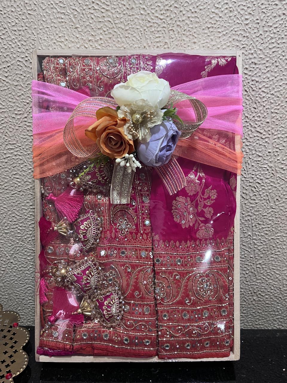 Traditional burgundy saree with gold embroidery and elegant presentation