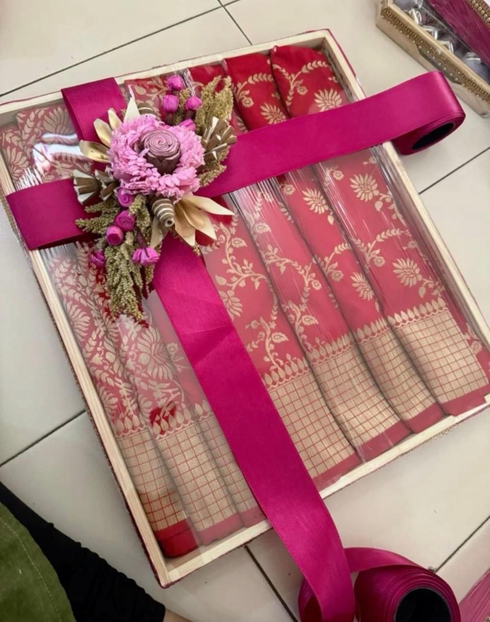 Pink traditional saree with gold motifs and floral arrangement